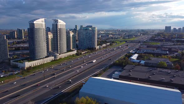 Toronto, Ontario Highway 401 during sunset with busy traffic and transport trucks delivering goods; alt