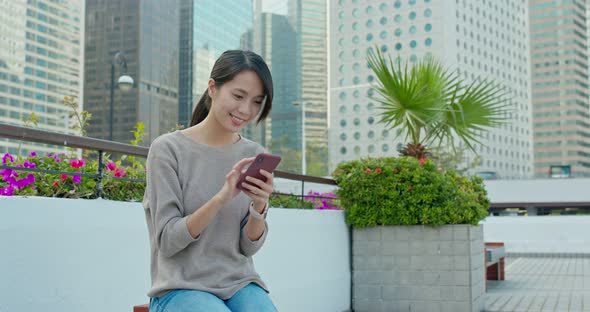 Woman use of mobile phone in city alt