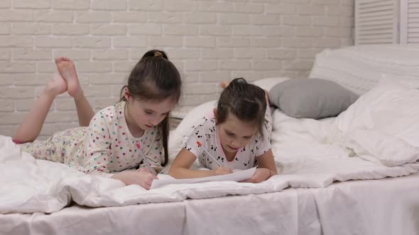 Kids Drawing Pictures While Lying on Bed