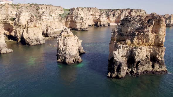 Emerald ocean calm waters with eroded rock formations and cliffs in Lagos, Algarve, Portugal alt