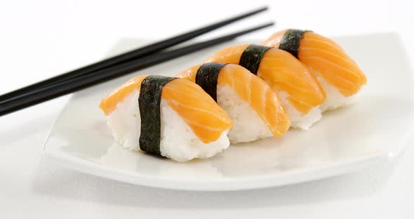 Sushi served on plate with chopsticks alt