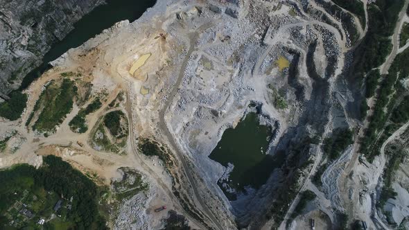 Aerial view of mining quarry with lots of machinery, excavators, trucks and drills