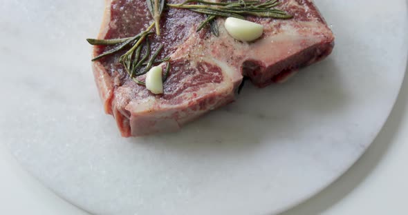 Fresh T-Bone or Porterhouse dry aged steak on marble cutting board. Marinate in olive oil alt