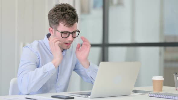 Young Man with Laptop Having Headache alt
