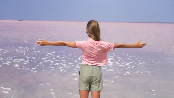 Girl on a Pink Salt Lake on a Sunny Summer Day