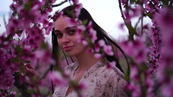 Young Beautiful Brunette Woman in a Blooming Spring Garden alt