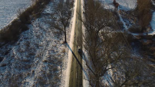 Car Driving Through Frozen Road At Sunset