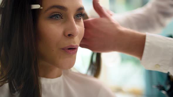 Handheld view of beautiful woman sitting in hair salon. Shot with RED helium camera  alt