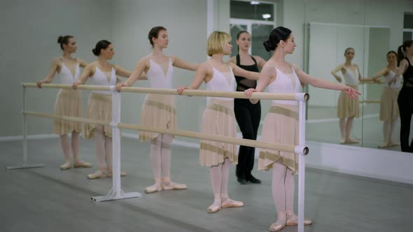Wide Shot Focused Young Caucasian Ballerinas Rehearsing Tendu As Choreographer Walking Talking in alt