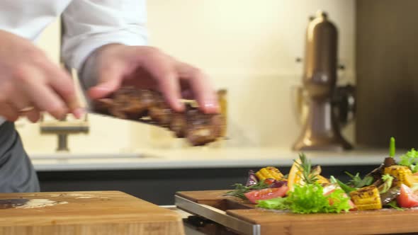 Cooking dinner in kitchen. pieces of grilled meat lie in dish with vegetables alt