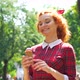 Cute red haired girl eating ice cream in park on sunny day - VideoHive Item for Sale