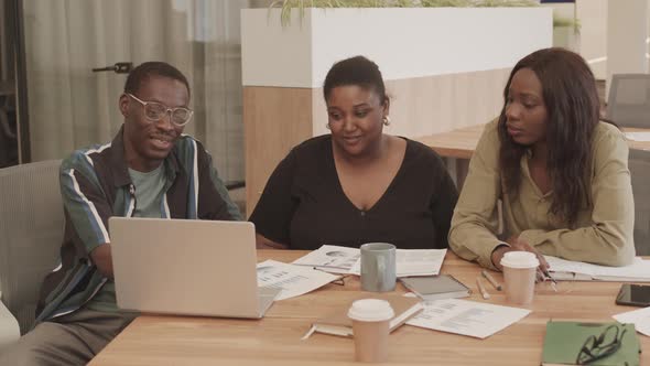 Colleagues Watching Presentation on Laptop alt