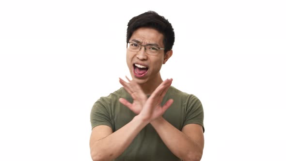 Portrait of Uptight Asian Man 20s Wearing Glasses and Casual Tshirt Shaking Head and Doing Stop alt