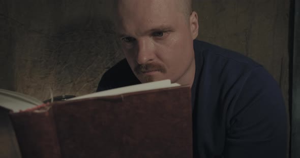 Close Up of a Portrait of Man Reading a Paper Book