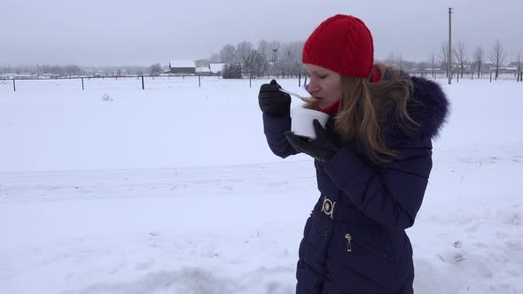 Woman with Red Cap Eat Hot Soup Outdoor at Cold Winter Time