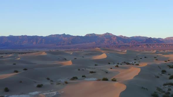 Sunset landscape for travel destination. Death Valley, California. Dunes and mountains in the backgr alt