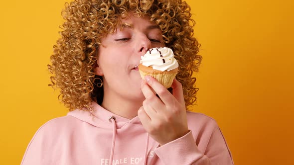 Close Up Portrait of a Hungry 30s Woman Biting Cream Cake alt