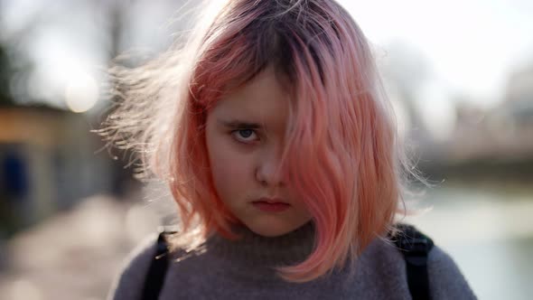 Chubby Little Girl with Pink Hair on City Street Troubled Teenager is Looking at Camera alt