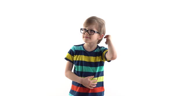 Little Schoolboy Poses in Studio on a White Background - Raises His Hand with a Finger at the Top