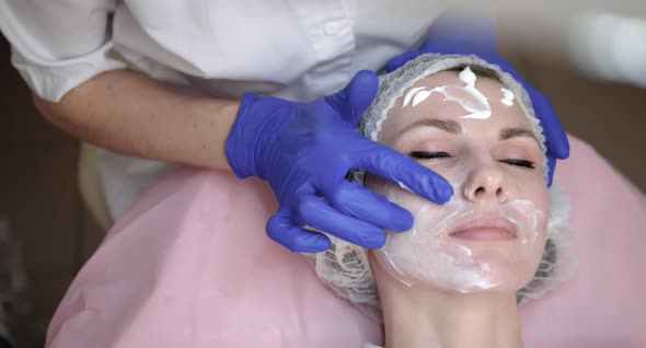 Close Up Top Shot of Pretty Young Lady Receiving Skin Treatment at Beautician alt
