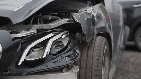Close Up of Black Wrecked Car with Broken Headlight Car Crash Accident Damaged Nature of Dent alt