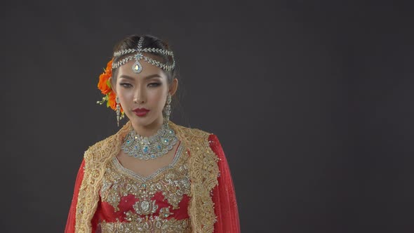 Shy yet alluring Indian bride in traditional dress poses for her wedding portraits alt