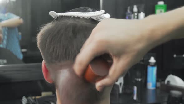 Barber Brushing Off the Hair of the Client After Giving Him a Haircut