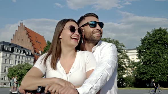 Summer Portrait of a Couple in Love on an Electric Scooter alt