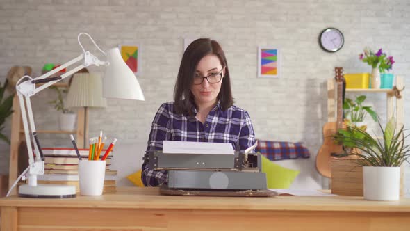 Young Woman Typing with Inspiration on a Typewriter alt