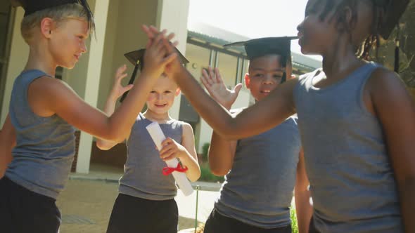 Video of happy diverse boys tossing hats after graduation alt