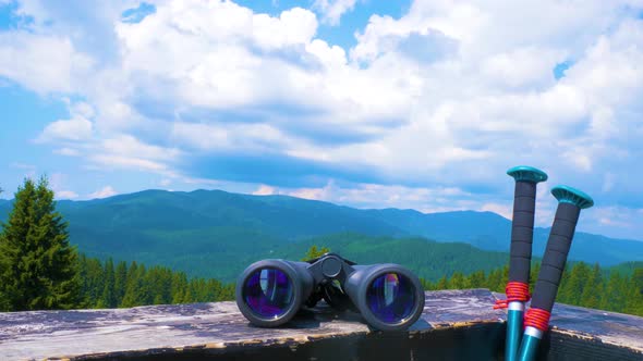 Hiking Sticks And Binoculars On The Wooden Table, Mountain Valley On A Background alt