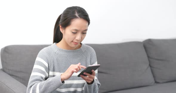 Woman using mobile phone at home alt