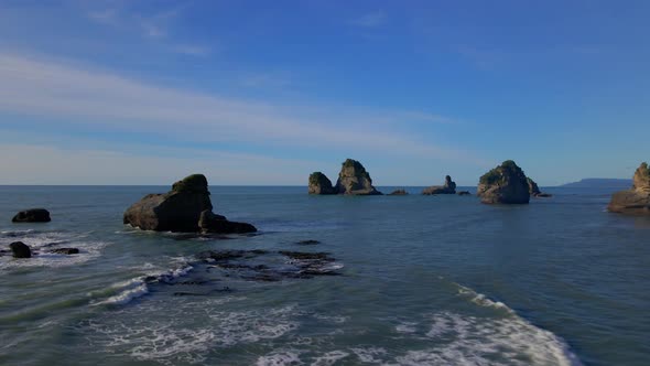 Rugged rocky shore cliffs off the coast in Tasman sea in New Zealand alt
