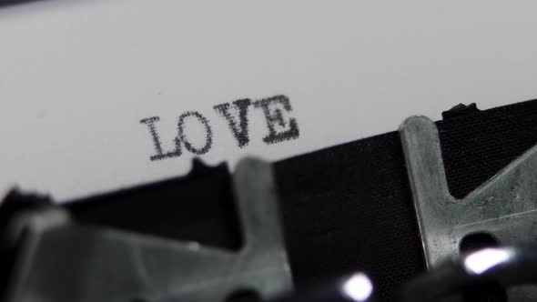 An old fashioned vintage typewriter spelling out the word Love alt