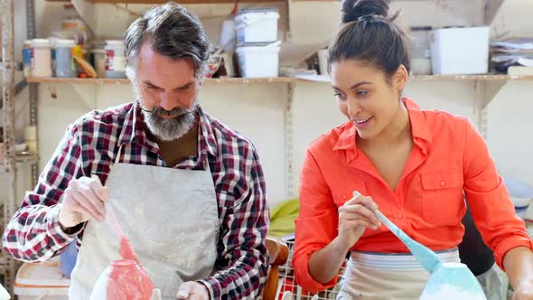Male and female potter painting ceramic bowl 4k alt