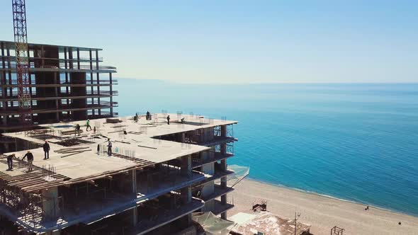 Drone view of construction site multi-storey buildings against background of sea alt
