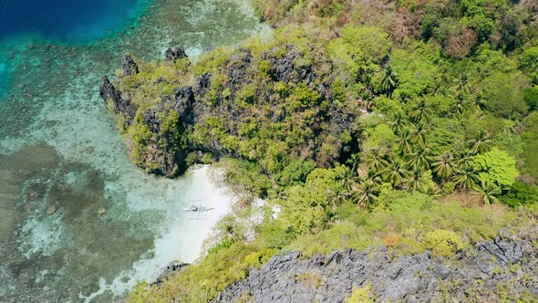 Aerial Footage of Small Beach Near Big Lagoon with Lonely Banca Local Boat on Paradise Sandy Beach alt