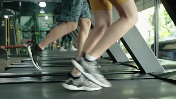 Healthy young people are exercising by running on a treadmill.