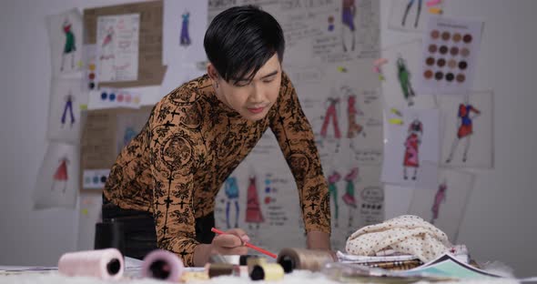 Tired fashion designer man draws a sketch clothing alt