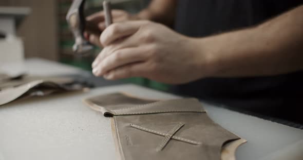 Cinematic Close Up View of Master Makes Holes in Leather Piece to Make Shoes in Resolution