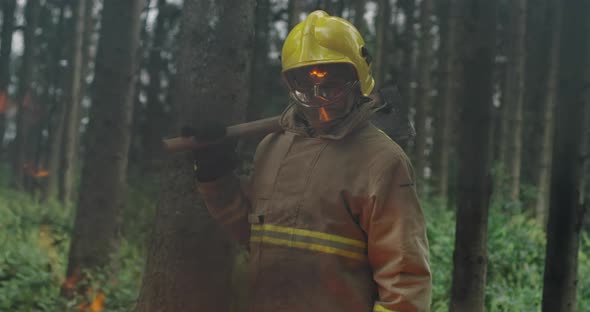 Portrait of Firefighter with Full Equipment Holds the Axe in His Hand alt