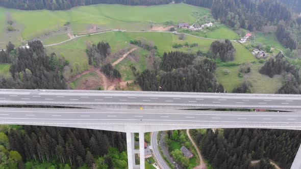 Aerial View of the Highway Viaduct on Concrete Pillars with Traffic in Mountains alt