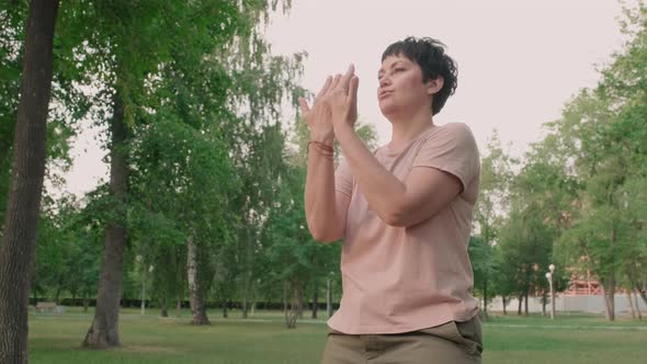 Female Qigong Trainer Practicing Outdoors alt