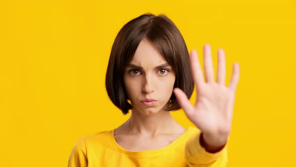 Determined Lady Gesturing Stop Shaking Head Expressing Disapproval Yellow Background alt