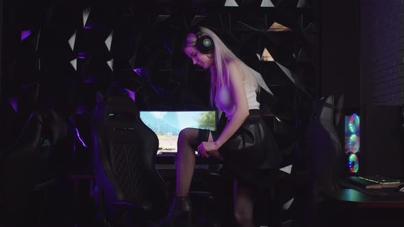 Blonde Sexy Gamer Girl Streamer Steps on a Chair and Tightens Up Her Fishnets Stockings alt