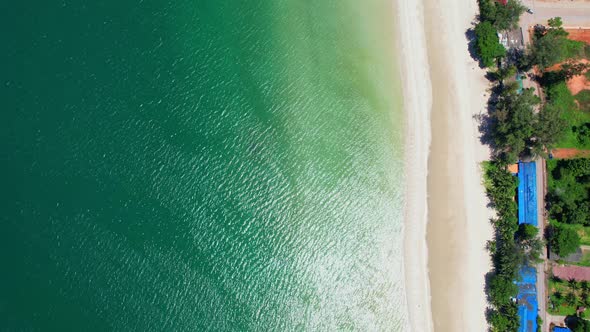 Aerial top view over city and sandy beach. coconut trees. alt