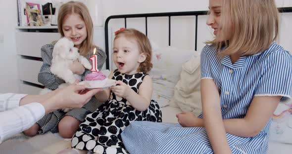 A Birthday Party for a Cute 1 Year Old Girl Surrounded By Her Older Sisters alt