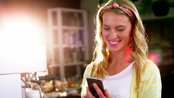 Woman using mobile phone in cafe alt