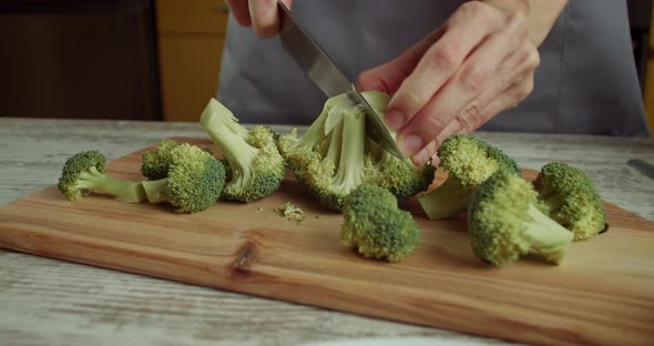 Chef Using a Knife Cutting Fresh Raw Broccoli Cabbage alt