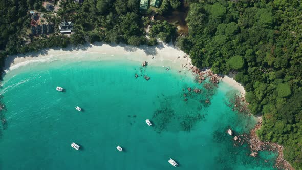 Vertical down aerial bird eye descent to bay Anse Lazio beach, Praslin alt